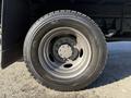 A close-up of a tire on a 2010 Ford F-450 showcasing a gray alloy wheel with multiple lug nuts and a rugged tread pattern