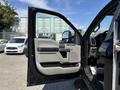 A 2022 Ford F-350 SD with an open driver's side door showing the interior door panel and controls