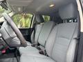 The interior of a 2013 RAM 1500 featuring two front seats in gray upholstery and a steering wheel without any visible buttons or controls