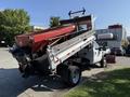 A 2008 Ford F-450 SD dump truck with a raised bed showing a red container and black tipping mechanism