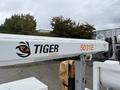 A white truck with a crane attachment labeled Tiger Cranes 5031E parked in a lot