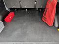 Interior of a 2017 Ford Transit van showing a flat cargo floor with a red toolbox and a red bag on the side