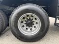 Close-up of a truck tire mounted on a 2013 Freightliner 114SD with visible tread pattern and wheel design