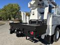 The image shows the rear of a 2013 International 7500 truck featuring a flatbed with a textured surface and various connectors and storage compartments