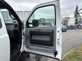 A 2013 Ford F-250 SD with an open driver's side door revealing the interior door panel and handle
