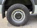 Close-up of a wheel from a 2017 Mercedes-Benz Sprinter featuring a silver alloy rim and a rugged tire with distinct tread patterns
