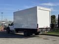 A white 2010 Ford F-450 box truck with a large enclosed cargo area is parked on a surface with visible wheels and rear lights