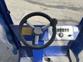 Steering wheel and control panel of a 2023 Bitimec SC415 with various buttons and levers in a blue color scheme