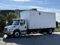 A white 2011 Freightliner M2 106 truck with a boxy cargo area is parked with visible side details and wheels