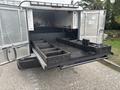 Open bed of a 2016 RAM 1500 truck featuring organized storage compartments and tools inside the cargo area