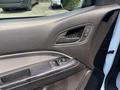 Close-up of the interior door panel of a 2017 Chevrolet Colorado featuring control buttons for windows and locks with a textured black surface
