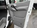 A 2017 Mercedes-Benz Sprinter door panel featuring a gray interior design with a handle and storage compartment