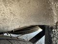 A close-up view of the undercarriage of a 2022 Mercedes-Benz Sprinter showing a tire and metal structure with some dirt and wear on the surface