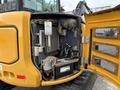 A 2017 John Deere 50G excavator with its engine compartment open showing various components including the radiator battery and air filter
