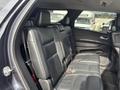 Interior view of a 2015 Dodge Durango showing the rear seating area with black leather seats and seatbelt buckles visible