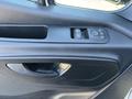 A close-up of the door panel controls of a 2021 Mercedes-Benz Sprinter 2500 featuring window switches and door handle controls