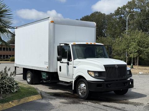 A 2014 International TerraStar truck with a white box cargo area and a black front grille is parked with its wheels on wet pavement