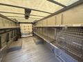 Interior of a 2012 Ford Econoline van featuring metal shelving on both sides and a floor space designed for cargo storage