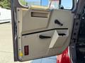 Interior door panel of a 1991 International 4600 featuring a handle, window crank, and a small storage pocket