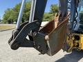 2013 John Deere 710K backhoe bucket with a rusty edge attached to an articulated arm