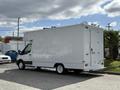 A 2016 Ford Transit cargo van with a large white box-like body and rear doors designed for storage or transportation purposes