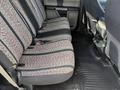 The interior of a 2018 Ford F-150 featuring bench seats with fabric covers in a patterned design and a rubber floor mat