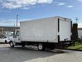 A white 2014 International TerraStar box truck with a flatbed and rear roll-up door parked at an angle