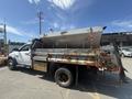 A 2016 RAM 5500 truck featuring a large metal dump bed and a partially raised salt spreader attachment on the back