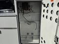 Interior view of an empty compartment in a 2009 Ford F-550 with wires hanging down and access to electrical components