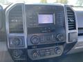 Dashboard of a 2018 Ford F-150 featuring a touchscreen display with media controls knobs and buttons