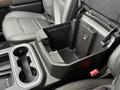 The interior console of a 2022 GMC Sierra 3500HD showing a spacious storage area with cup holders and a lid that is open