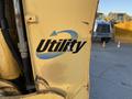 A yellow 2007 Komatsu WB156PS-5 backhoe loader featuring the utility logo on its side
