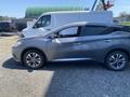A 2017 Nissan Murano in gray parked with its driver-side door slightly open