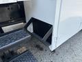 A close-up of a black handle attached to a white panel on a 2006 Sterling Acterra truck with visible steps underneath