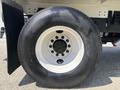 A close-up of a large white wheel with a black tire mounted on a 2015 Ford F-750 truck