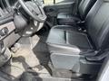 Interior view of a 2023 Ford Transit featuring two black leather front seats and a steering wheel