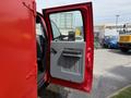 A red 2013 Ford F-550 with an open passenger door revealing a gray interior and a door handle on the inside