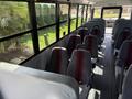 Interior view of a 2011 Freightliner B2 school bus featuring multiple rows of gray seats with red stripes and a clear aisle running down the center