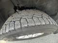 Close-up of a tire from a 2015 RAM 1500 showing detailed tread patterns and a metallic wheel rim