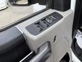 Close-up of the driver-side door panel of a 2019 Ford F-350 SD featuring window controls and a mirror adjustment switch