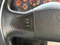 Close-up of the steering wheel of a 2013 International 4300 featuring a control button with labels for open and close