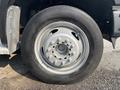 Close-up of a silver wheel and tire of a 2009 Ford F-550 showing detailed lug nuts and tread pattern