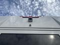 A 2020 Chevrolet Express with a white exterior and several camera features mounted on the rear