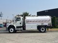 A white 2010 Freightliner M2 106 fuel truck with a large tank and red accents parked on a street