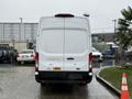 A white 2023 Ford Transit van viewed from the rear with a cargo area and distinctive taillights
