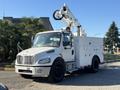 A white 2006 Freightliner M2 106 bucket truck equipped with a hydraulic lift and tool storage compartments on the side