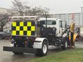 A 2016 Freightliner 108SD truck equipped with a snow plow and a yellow and black reflective rear display