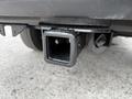 A receiver hitch opening on a 2018 Ford F-150 showing a rectangular metal socket with a rough finish