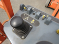Close-up of the control panel of a 2009 JLG E300AJP lift featuring a joystick and several control switches with labels and symbols for operation