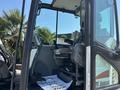 Cab of a 2010 Bobcat E80 excavator with a driver's seat control panel and foot pedals visible inside the cabin